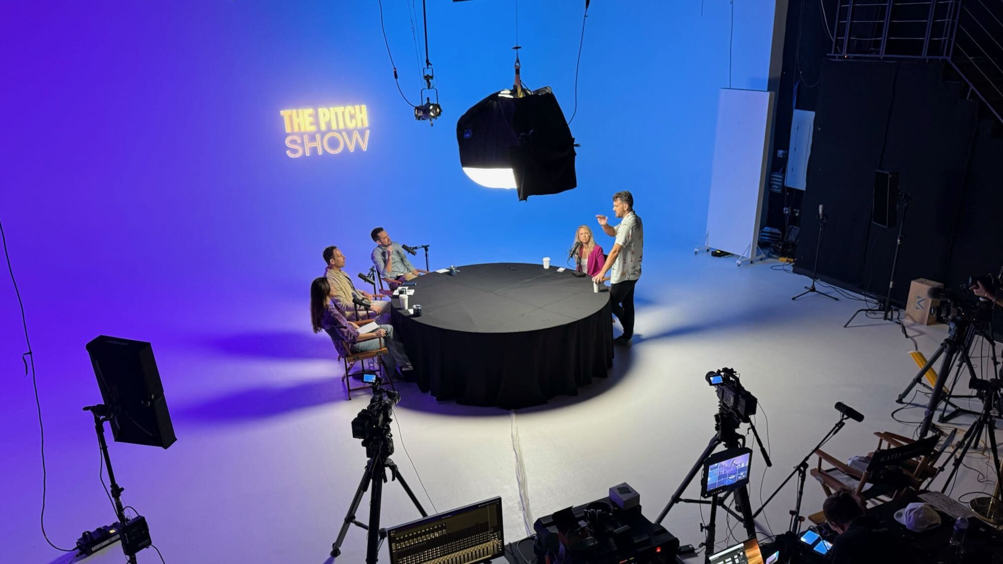 A founder pitching to investors around the table at The Pitch studio